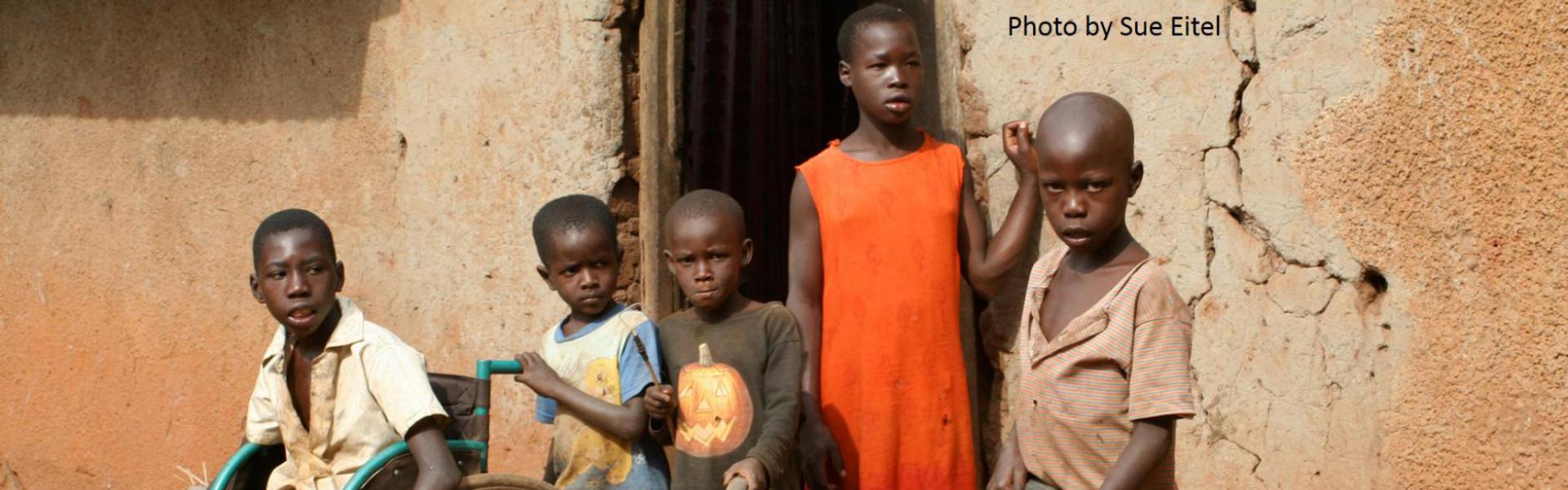 Four boys and a girl outside an building in Africa