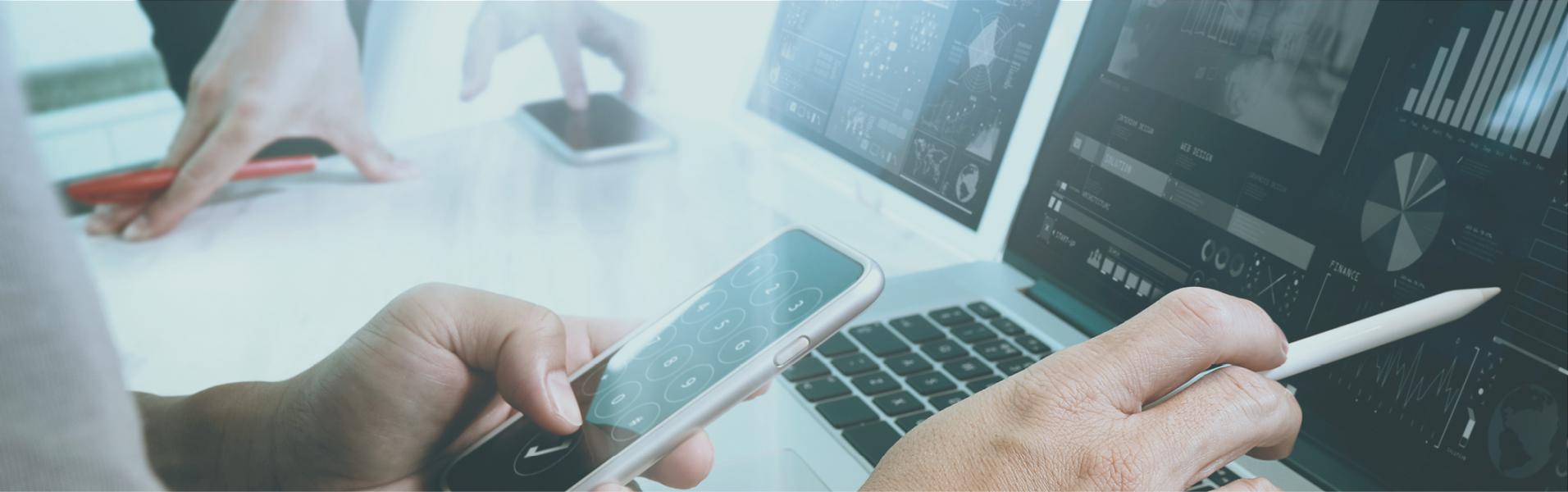   Researcher using various devices such as a mobile phone and laptop for data analysis.