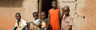 Four boys and a girl outside an building in Africa