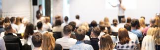 Speaker at a conference explains his findings to a group of attendees