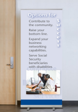 Banner featuring two employees working at a call center. One of the employees is blind and is using assistive technology.