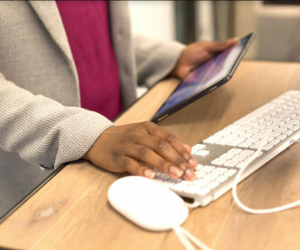  Person looking at tablet while typing on keyboard. Licence: Creative Commons Attribution UKBlackTech