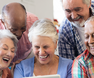 Five seniors viewing an iPad