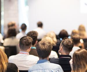 Speaker at a conference explains his findings to a group of attendees