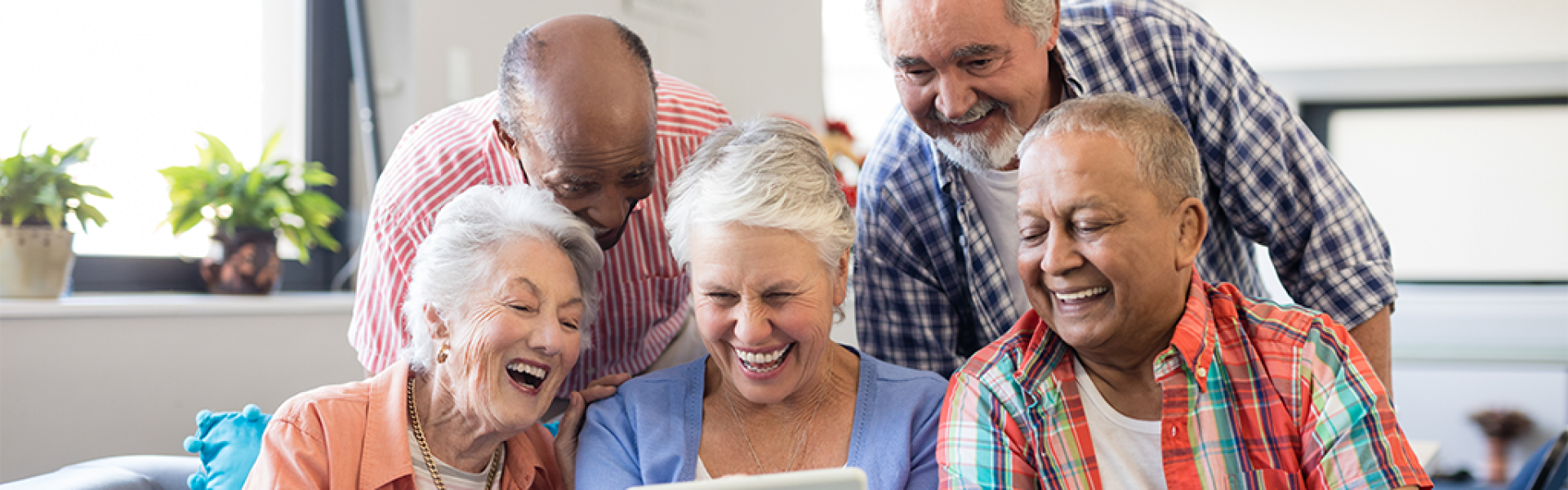 Five seniors viewing an iPad